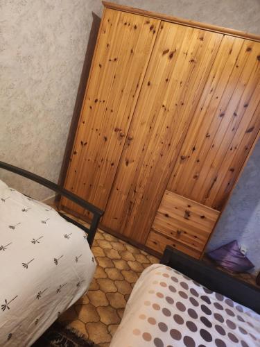 una camera da letto con una parete rivestita in legno e 2 letti di Appartement Parc Forestier 3-4 personnes a Bruxelles