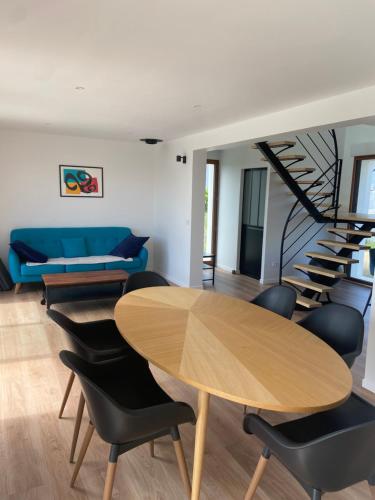 un salon avec une table et des chaises ainsi qu'un escalier en colimaçon dans l'établissement Vue Mer Très belle plage à pied Maison proche Lesconil Loctudy, à Loctudy