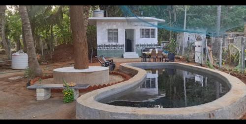 una casa con piscina frente a una casa en Lotus en Kanyakumari