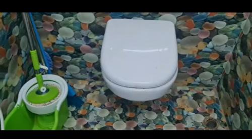 a bathroom with a toilet in a mosaic floor at Lotus in Kanyakumari