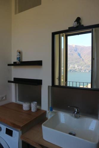 ein Badezimmer mit Waschbecken und Spiegel in der Unterkunft Emy House Charming Apt Stunning Views /Balcony in Carate Urio