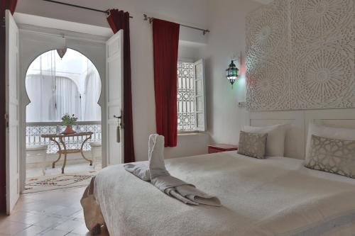1 dormitorio con 1 cama grande y cortina roja en Riad Morocco Sky, en Marrakech
