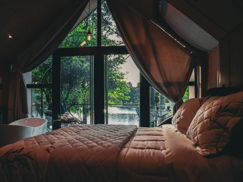 una camera con un letto di fronte a una finestra di Celeiro Lake Village - Soft Opening a São Francisco de Paula