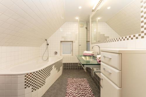 ein Badezimmer mit einer Badewanne und einem Waschbecken in der Unterkunft Appartements Knappenhaus by Schladming-Appartements in Schladming