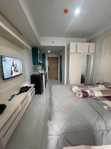 a bedroom with a large bed and a flat screen tv at Delft Apartment - Sea View Studio Flat at Losari Beach in Makassar