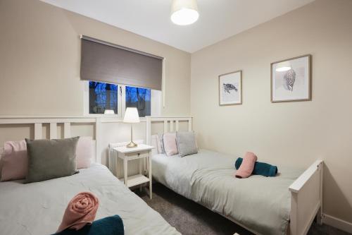 1 dormitorio con 2 camas y ventana en Richmond House - 5 Bed, Sleeps 10, Great for Workers & Groups, Netflix & FREE Parking, en Manor
