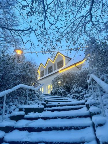 a snow covered staircase leading to a house with lights at Hotel Wilhelmshöhe in Warnemünde