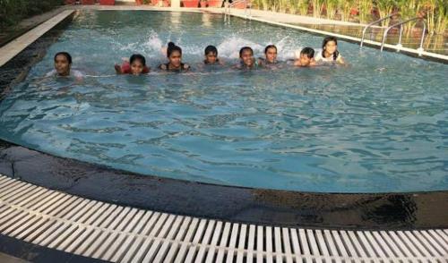 Corbett Wild Nature View Resort في رامناجار: وجود مجموعة أشخاص في المسبح