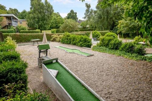 un jardín con mesa de billar verde y bancos en Lynge kro & Hotel 