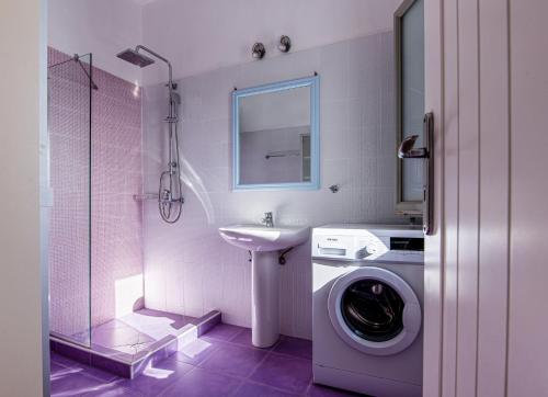 a bathroom with a washing machine and a sink at Maison a la Plage in Faros