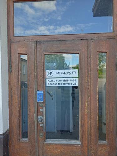 a wooden door with a sign on it at Hotelli Posti in Äänekoski