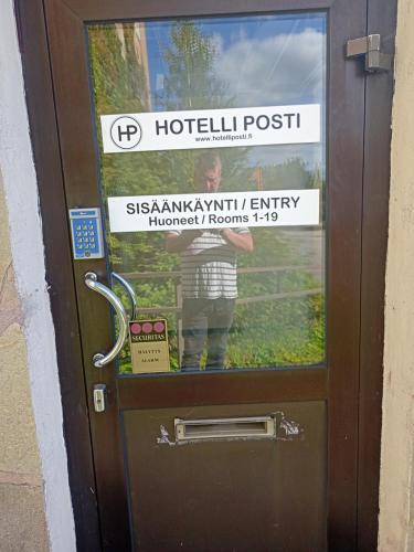 a door with a sign on it with a person on it at Hotelli Posti in Äänekoski
