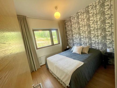 1 dormitorio con cama y ventana en Holiday Home Ylläs Villas, en Ylläsjärvi