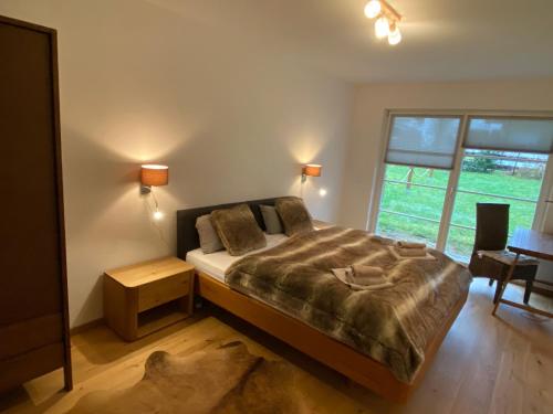 um quarto com uma cama grande e uma janela em Traumhafte Ferienwohnung im alpinen Stil in Traumlage em Schönau am Königssee