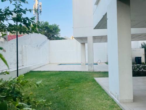 une cour vide avec clôture blanche et pelouse dans l'établissement Cozy apartment close to city center, à Santa Cruz de la Sierra