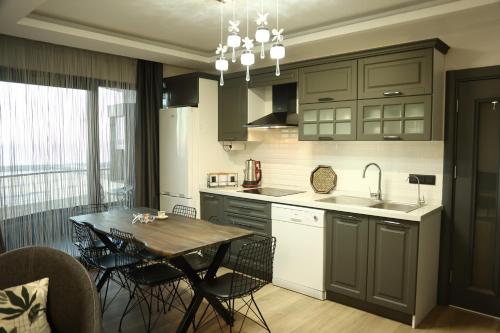 a kitchen with a table and a dining room at Dreams Inn Luxury Residences & Lifestyle in Cimenli