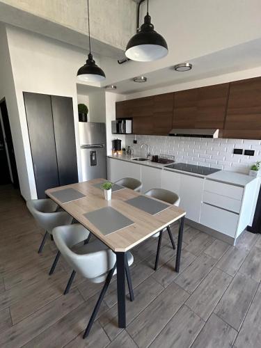a kitchen with a wooden table and chairs at EÓN 13 - Apto moderno con aire acondicionado in Guatemala