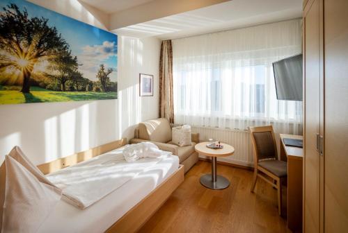 ein Hotelzimmer mit einem Bett und einem Tisch in der Unterkunft Vital-Hotel-Styria in Fladnitz an der Teichalm