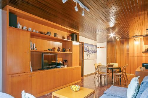 a living room with a television and a dining room at Apartamento en SAPPORO in Vielha