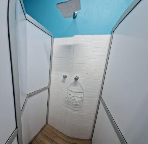 ducha con puerta de cristal y toalla en SAINT PETER'S LLAMA HOSTAL en La Paz