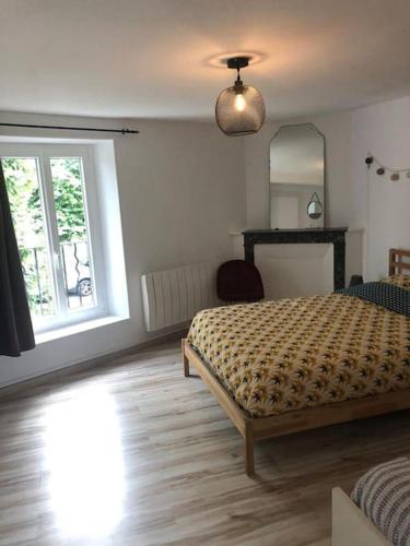 une chambre avec un lit, une fenêtre et un miroir dans l'établissement Gîte le long rocher, à Veneux-les-Sablons