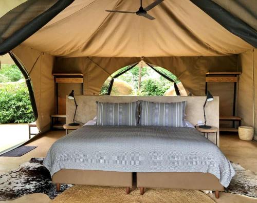 1 dormitorio con 1 cama en una tienda de campaña en osim mara camp, en Sekenani
