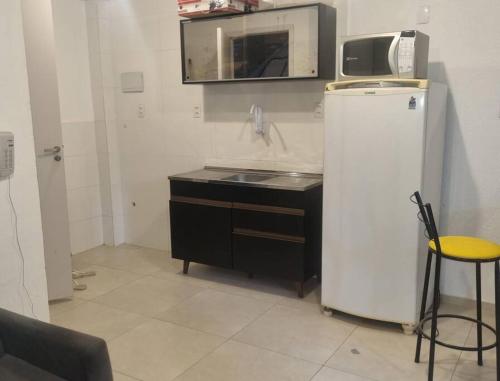 una pequeña cocina con fregadero y nevera. en Estúdio Centro RJ Pequena África en Río de Janeiro