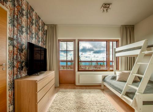 a bedroom with a bunk bed and a television at Holiday Home Ylläs Villas in Ylläsjärvi