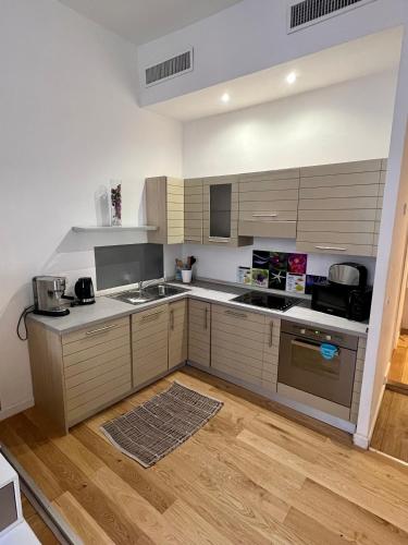 Il comprend une cuisine avec des murs blancs et du parquet. dans l'établissement Place Massena, à Nice