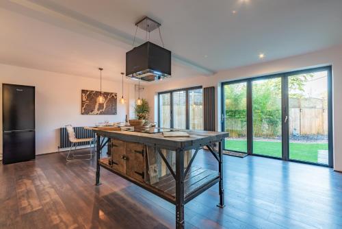 a kitchen with a large wooden table in a living room at Cotswold holiday let with hot tub - The Old Garage in Chipping Norton