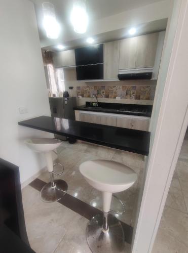 a kitchen with a counter and two stools in it at Reserva del Peñon in Girardot