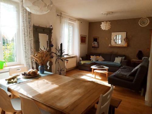 un salon avec une table en bois et un canapé dans l'établissement Gîte Les Lilas, à La Genevraye