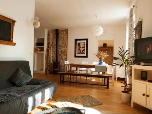 un salon avec un canapé et une table dans l'établissement Gîte Les Lilas, à La Genevraye