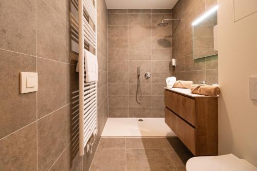 uma casa de banho com um chuveiro, um WC e um lavatório. em SYBA Gastenverblijf em Evergem