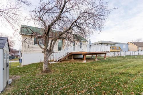 una casa con terraza y un árbol en el patio en SmartHome-Omaha Homestay Rooms en Omaha