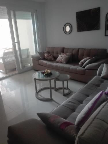 ein Wohnzimmer mit einem Sofa und einem Tisch in der Unterkunft s+2residence amwej in Sousse