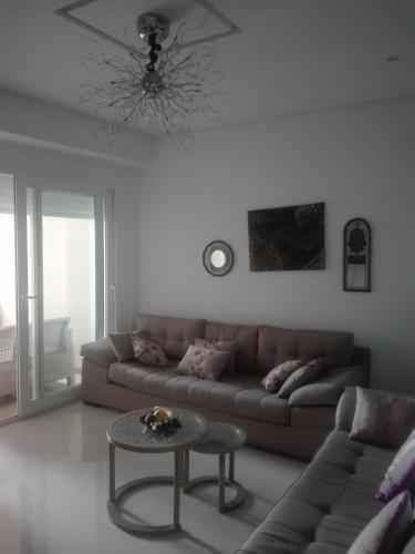 sala de estar con sofá y mesa en s+2residence amwej, en Sousse