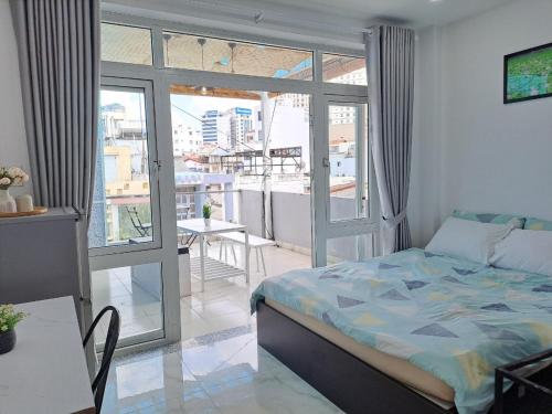ホーチミン・シティにあるCozy studio at Hai Ba Trung st., Dist 3 near Tan Dinh marketのベッドルーム1室(ベッド1台付)、バルコニー(テーブル付)