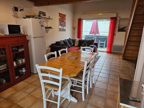 a kitchen and dining room with a wooden table and chairs at Maison 3 étoiles à 50m mer plages îles nature piscine chauffée jacuzzi privé WIFI in Le Port-des-Barques