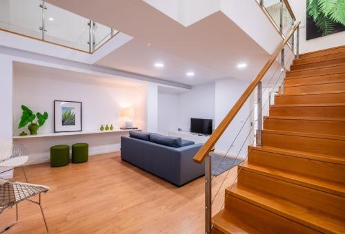 a living room with stairs and a couch at Ponta Delgada Flats - HOST & CHILL in Ponta Delgada
