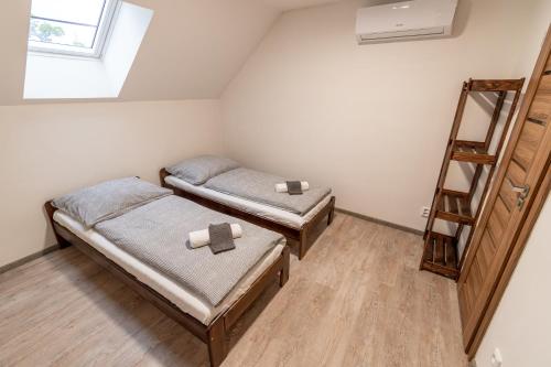 a room with two twin beds and a ladder at Búda u Kramářů - penzion Robin in Mutěnice