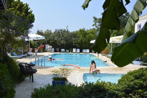 a woman is sitting in a swimming pool at Paradise Garden Apartments in Gumusluk