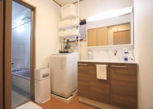 a kitchen with a refrigerator and a sink at たび宿SeKKoku in Takagi