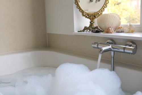 a bathtub filled with a cloud shaped bath tub filler at Spacious apartment with garden in Amsterdam