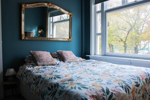 a bedroom with a bed with a mirror on the wall at Spacious apartment with garden in Amsterdam