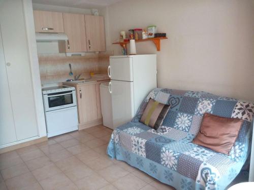 Il comprend une petite cuisine avec un canapé et un réfrigérateur. dans l'établissement Appartement cosy avec accès plage et parking, 4 couchages à Marseillan-Plage - FR-1-387-92, à Marseillan