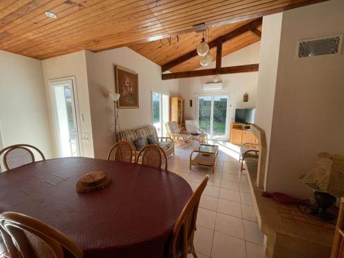 une salle à manger avec une table et un salon dans l'établissement Maison Familiale Près de la Plage avec Grand Jardin et Parking Privé - FR-1-413-108, à Capbreton