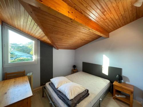 une chambre avec un lit avec un plafond en bois dans l'établissement Maison Familiale Près de la Plage avec Grand Jardin et Parking Privé - FR-1-413-108, à Capbreton