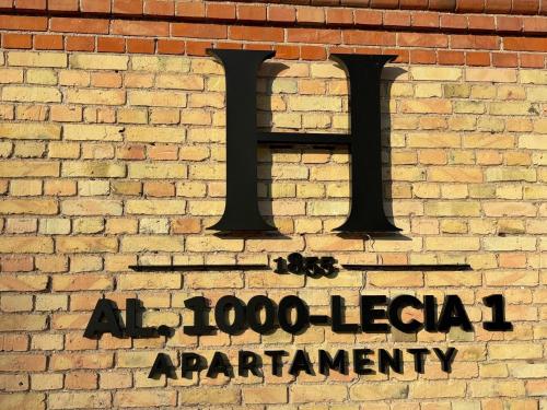 a sign on the side of a brick wall at ApartHotel Centrum - parking free in Białystok