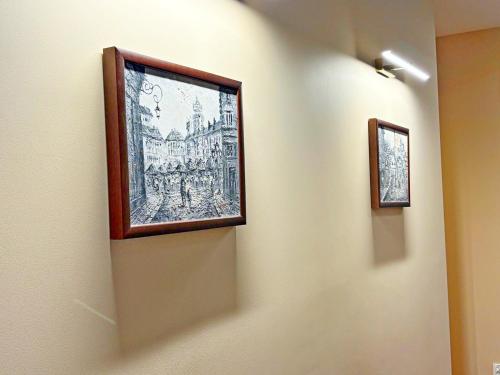 two framed pictures on a wall in a room at ApartHotel Centrum - parking free in Białystok